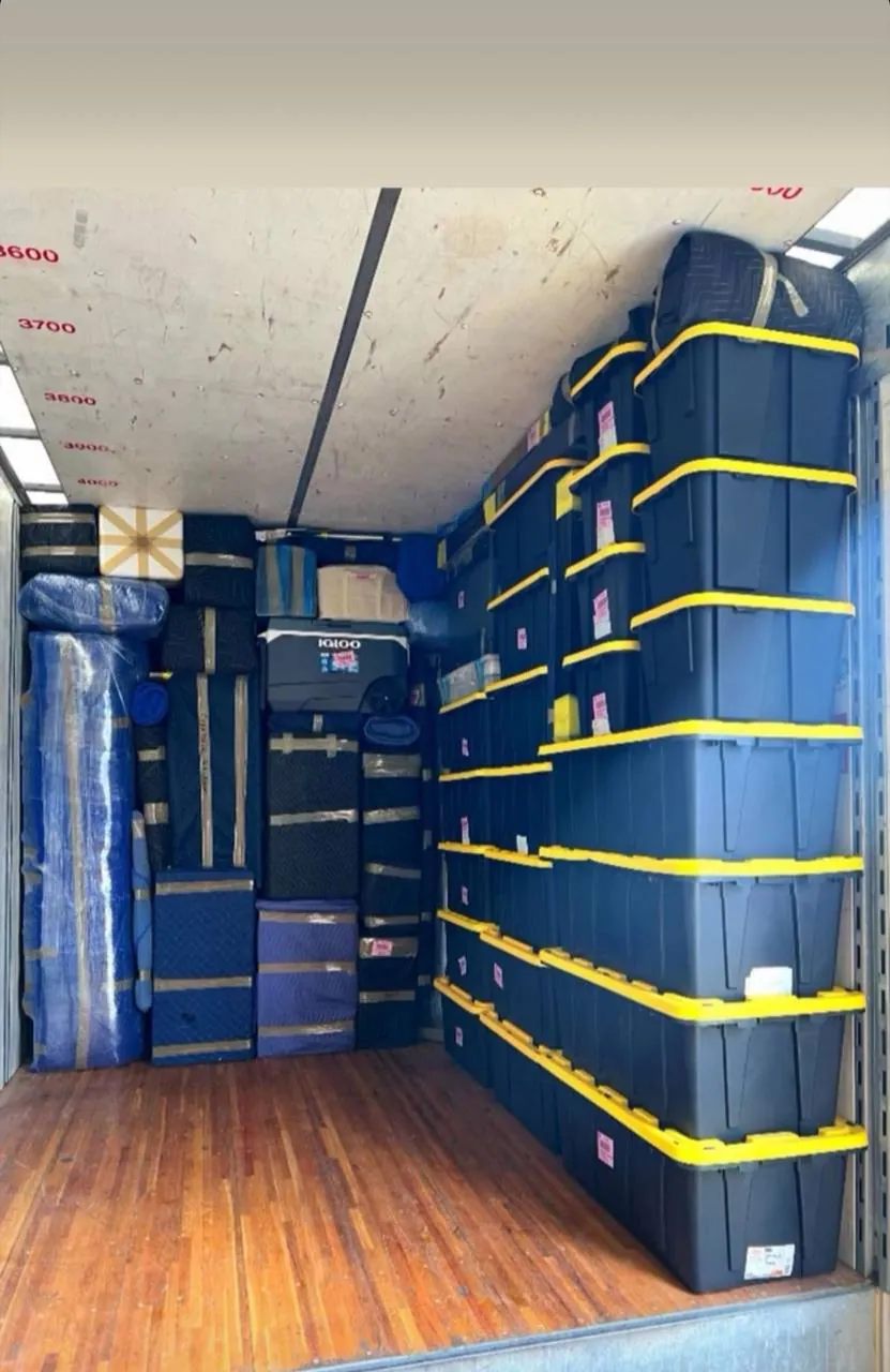 Truck interior with blanket-wrapped furniture strapped in