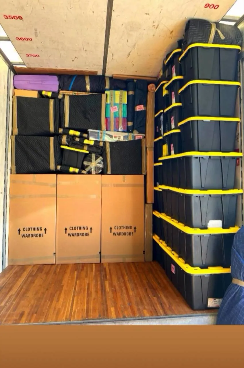 Truck interior with furniture and boxes secured by straps