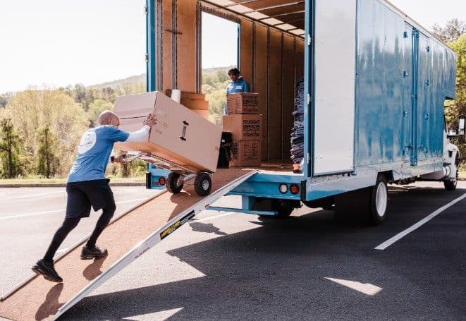 Movers carrying furniture up a truck ramp