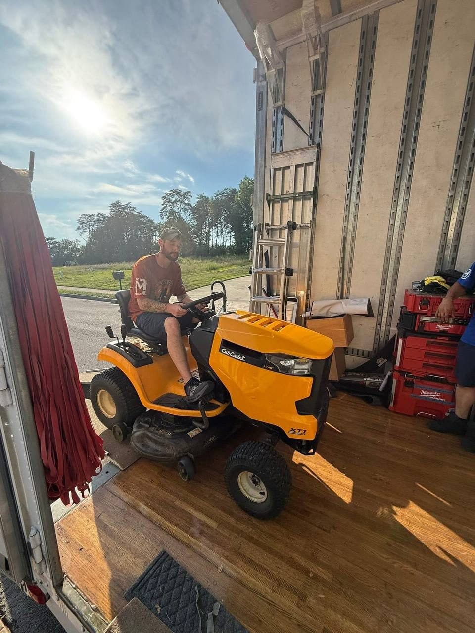 Riding mower driven up a ramp into a box truck